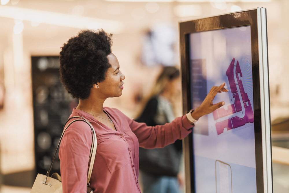 A shopper using a self-service option, allowing her to access shopping navigating information